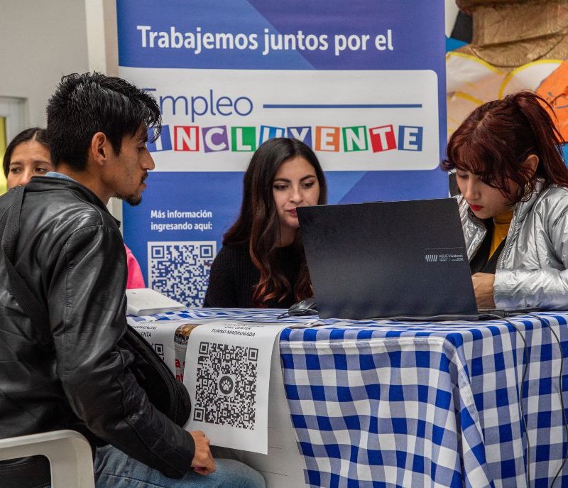 Imagen de una persona joven recibiendo orientación en una feria de empleo