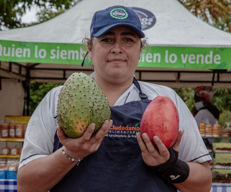 Imagen relacionada con una mujer campesina que exhibe frutas