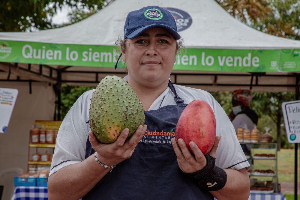 Imagen relacionada con una mujer campesina que exhibe frutas