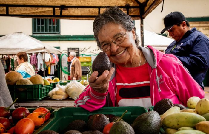Imagen relacionada con una mujer que ofrece sus productos en un mercado campesino