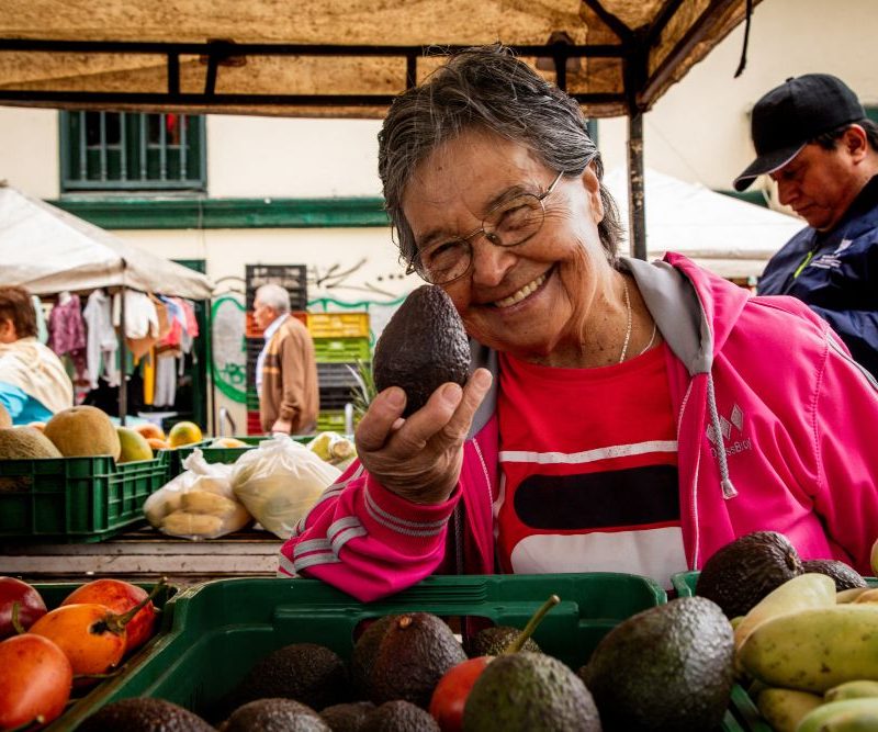 Imagen relacionada con una mujer que ofrece sus productos en un mercado campesino
