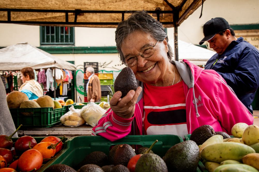 Imagen relacionada con una mujer que ofrece sus productos en un mercado campesino