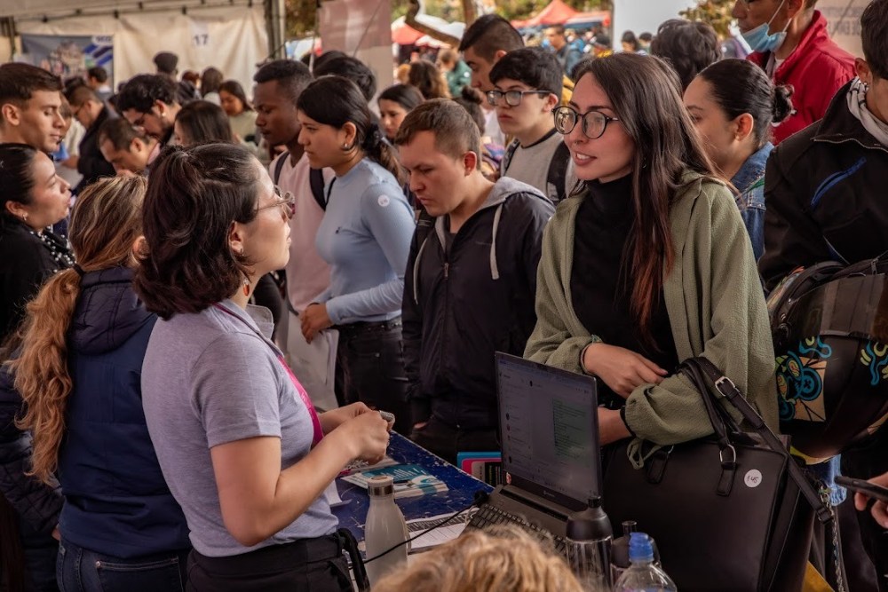 Imagen relacionada con un grupo de jóvenes en una mesa de inscripciones para una feria de empleo de Bogotá
