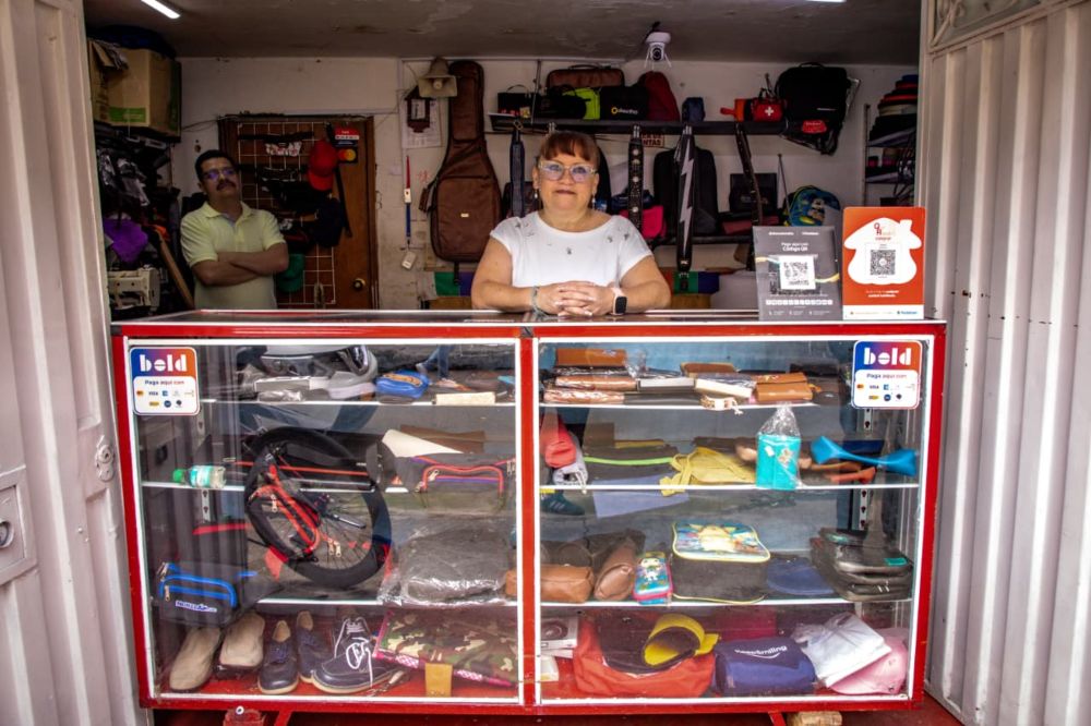Imagen relacionada con una mujer emprendedora en la entrada de su negocio