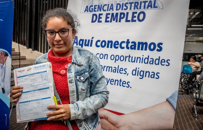 Imagen relacionada con una mujer que presenta su hoja de vida en una feria de empleo