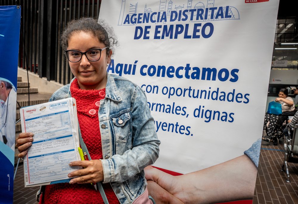 Imagen relacionada con una mujer que presenta su hoja de vida en una feria de empleo