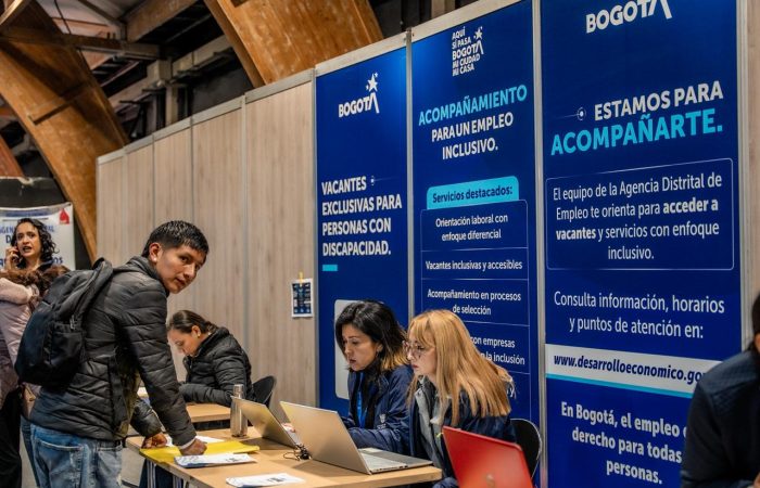 Imagen relacionada con una persona que se acerca a la mesa de registro en una feria de empleo