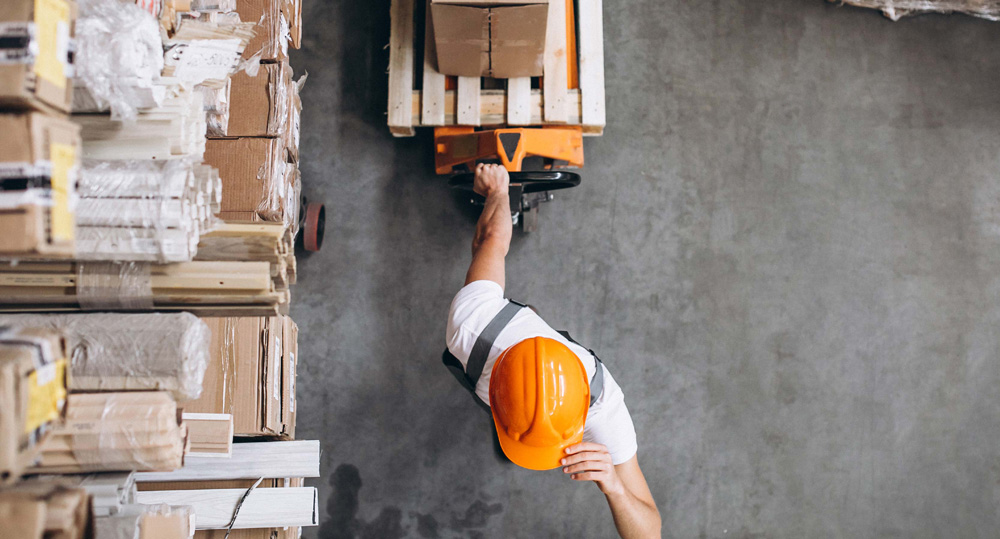 Vista superior de trabajador con casco moviendo mercancía