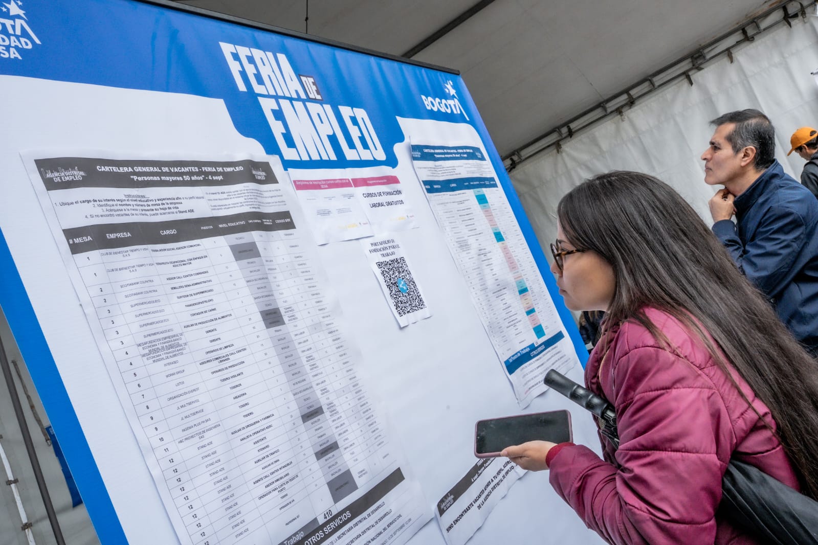 Imagen relacionada con una persona en feria de empleo revisando listado