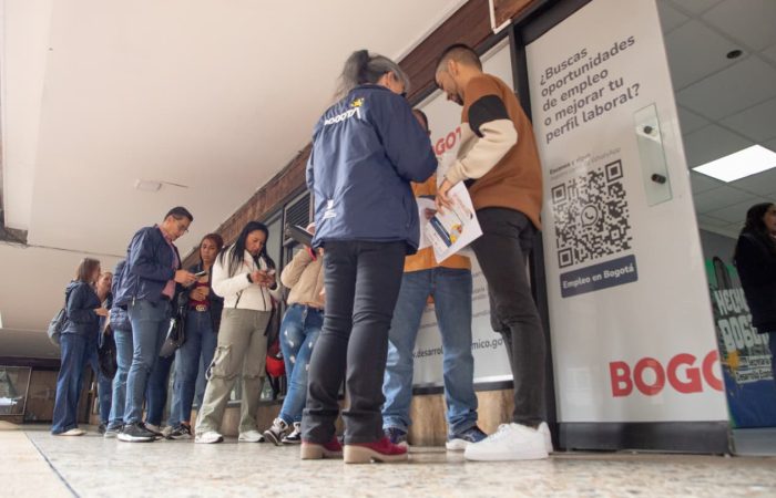 Imagen relacionada con unas personas que revisan listado de vacantes en una feria de empleo