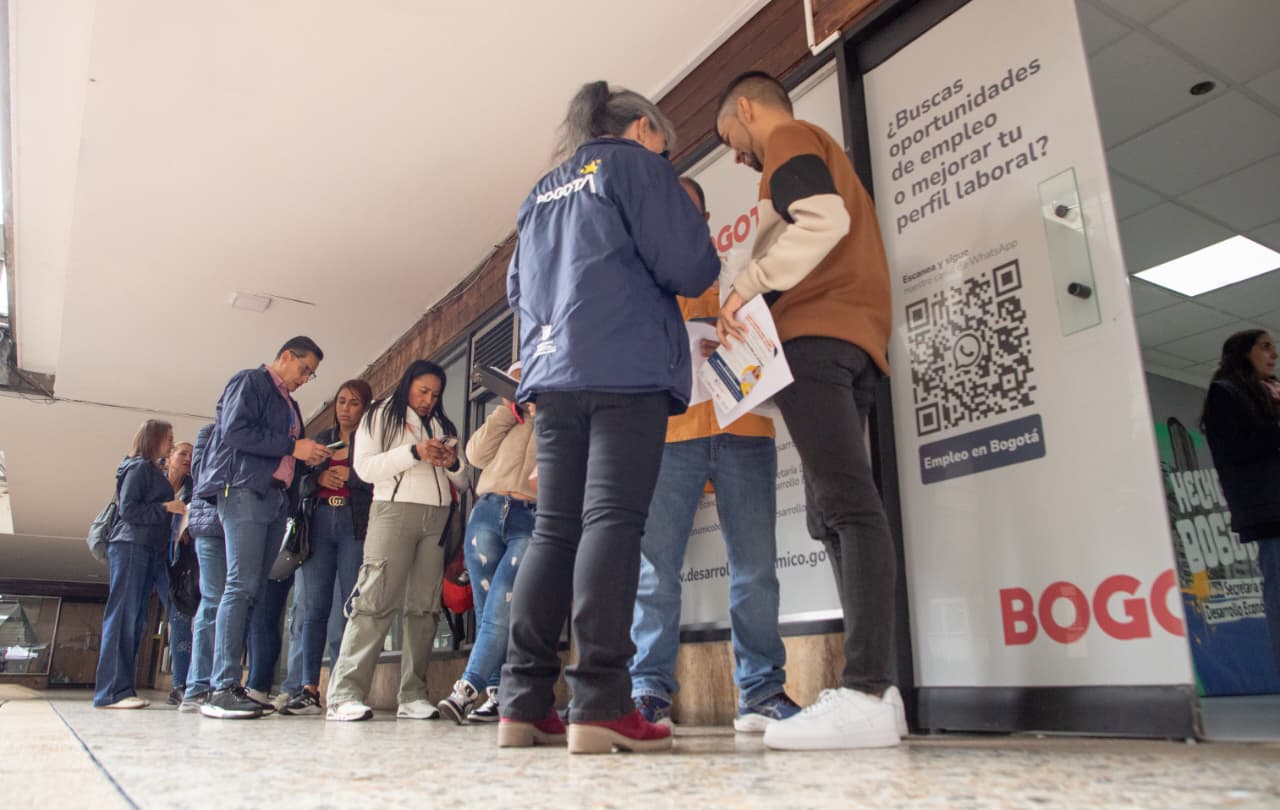 Imagen relacionada con unas personas que revisan listado de vacantes en una feria de empleo